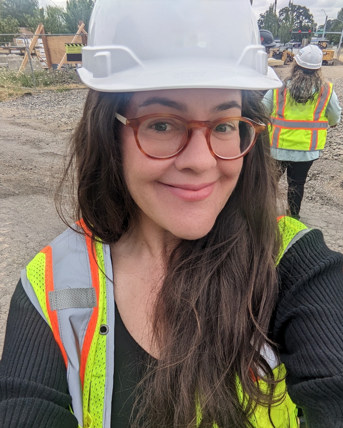 Charis Peters, founder of Felis Advisory & Bookkeeping, wearing a white hard hat on a construction site